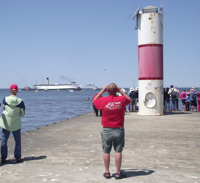 Spectators watch the Keewatin as it is towed out of the channel from Kalamazoo Lake into Lake Michigan on its way to Canada on Monday, June 4. Jim Hayden/Sentinel staff