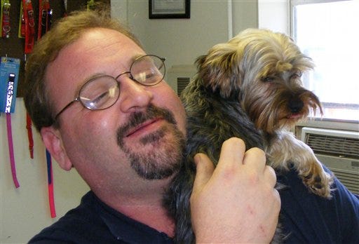 This June 5, 2012, photo shows truck driver Michael Siau after he was reunited with his dog, Rambo, in Hannibal, Mo. Siau was en route to North Dakota and made it all the way to Cedar Rapids, Iowa when he realized Rambo wasn't in the back seat. Rambo waited at the rest area where he was mistakenly left until Siau's truck route sent him back through Hannibal to pick him up.