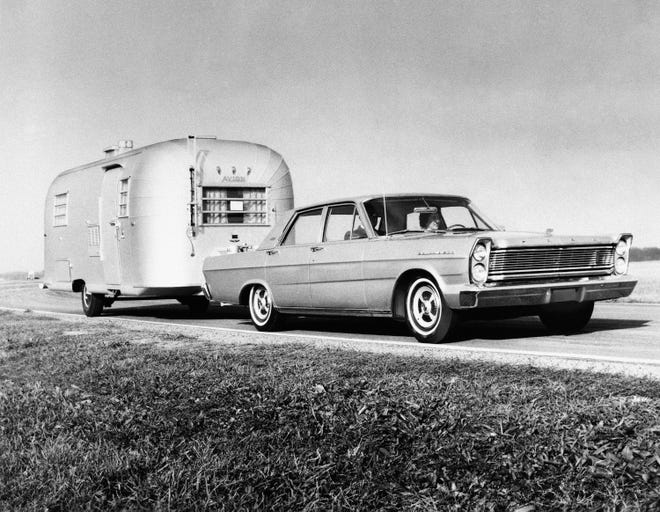 This October, 1964 file photo provided by the Ford Motor Company, shows the 1965 Ford Car, with a travel trailer. The type of car a family chooses before a family road trip can help ease discomfort.