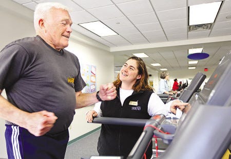 In this 2011 photo, Synergy Health & Fitness trainer Shannon Ward advises patient Ed Johnson as he runs on the treadmill, taking part in a program that studies the effects of exercise in cancer patients.