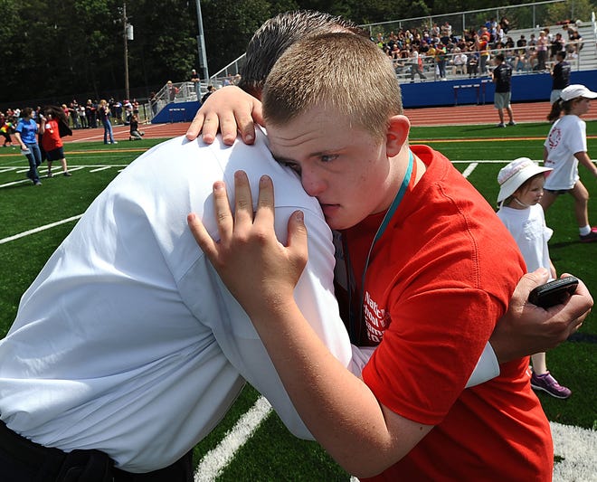 Ben Allard, 13, of Franklin, a student in the Accept program at Ashland Middle School, gets a hug from his dad, Michael, after competing in the 50-meter run during the Natick School Day Games at Natick High School yesterday. The annual Natick Public Schools competition is a local program of the Massachusetts Special Olympics.