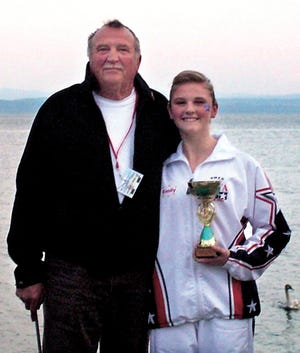 Emily Rinehart, with her grandfather, Billy Lough, holds the silver medal she won in the World Twirling Competion in Neuchatel, Switzerland. She competed in the Rhythmic Twirl category.