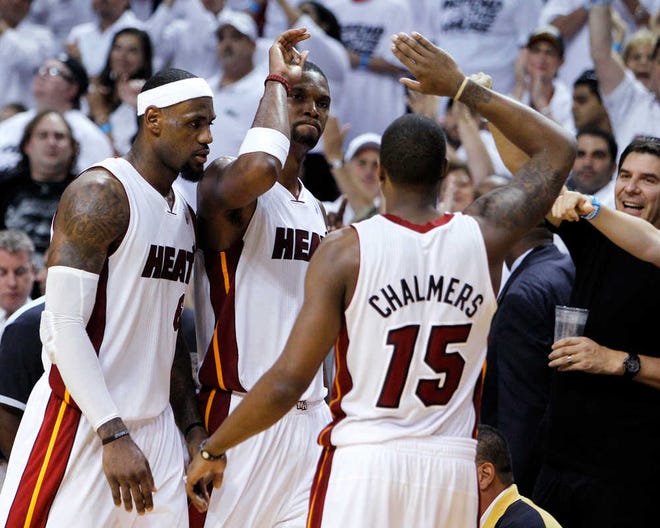Miami Heat's Chris Bosh, center, Mario Chalmers, right, and LeBron James congratulate each other during the second half of Game 7 of the NBA basketball playoffs Eastern Conference finals against the Boston Celtics, Saturday, June 9, 2012, in Miami. The Heat defeated the Celtics 101-88. (AP Photo/Lynne Sladky)