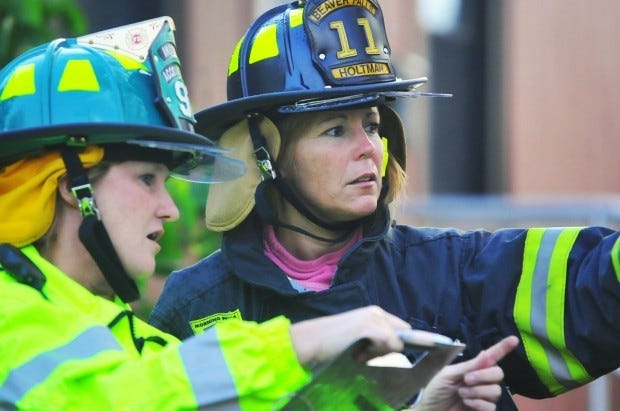 Angelette Holtman is a volunteer for the Beaver Falls fire department. Pictured she works at a training exercise at Pulaski Homes in April with Bonnie Duffy, accountability officer for the Industry fire department.