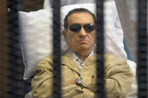 In this June 2, 2012 file photo, Egypt's ex-President Hosni Mubarak lies on a gurney inside a barred cage in the police academy courthouse in Cairo, Egypt, during a hearing in which he was sentenced to life in prison for his role in the killing of protesters during the revolution in spring of 2011. Mubarak's health sharply deteriorated Wednesday, June 7, 2012, and specialists were evaluating whether to transfer him to a better-equipped hospital outside the penal system, security officials said.