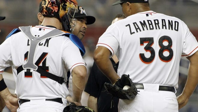 Miami Marlins manager Ozzie Guillen (center) speaks with pitcher Carlos Zambrano (38) after he gave up five runs to the Tampa Bay Rays in the third inning of the Marlins' 13-4 loss on Saturday, June 9, 2012, in Miami.