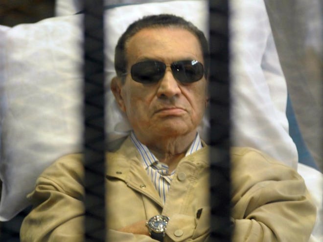 Egypt's ex-President Hosni Mubarak lies on a gurney inside a barred cage on June 2 in the police academy courthouse in Cairo, Egypt, during a hearing. (AP Photo/File)