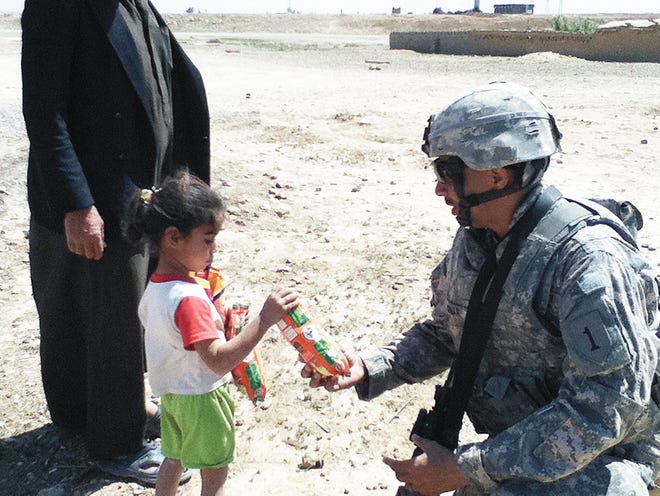 MAJ. Lane Bomar, formerly of Fort Jones, hands out food to the Iraqi people during his recent deployment.