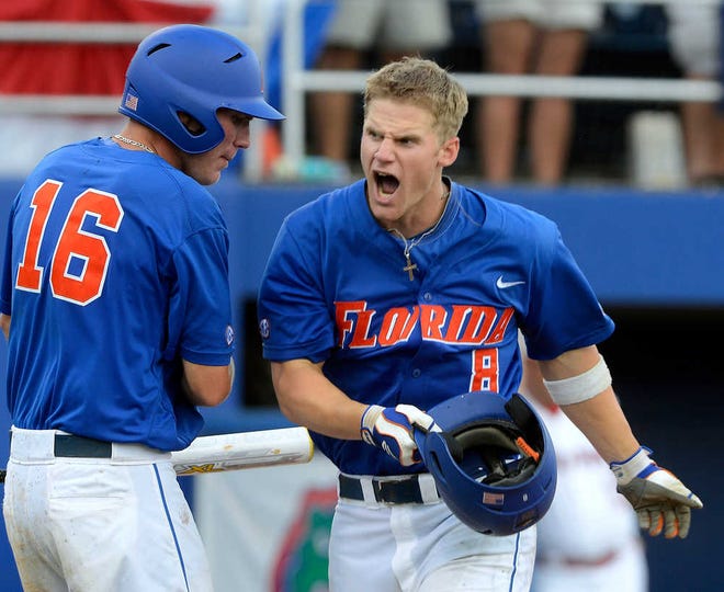Florida's Daniel Pigott (8) celebrates with Justin Shafer after scoring in the 10th inning against North Carolina State Sunday during an NCAA super regional game.