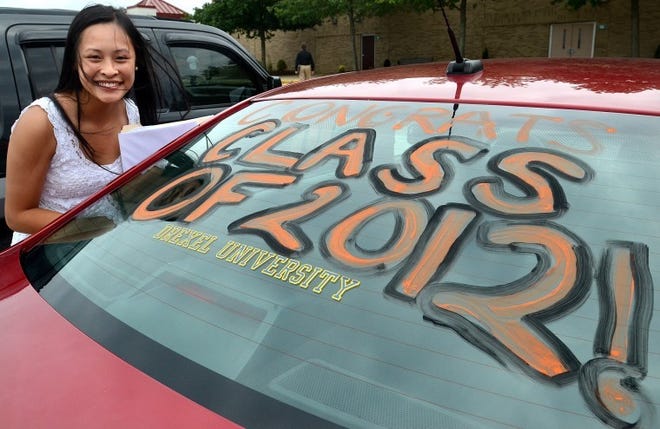 Cherokee High School graduating senior Jody Lo of Evesham is all smiles next to her decorated car.