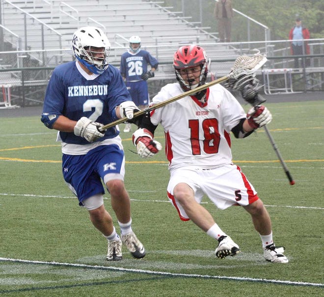 Kennebunk's Nicco Delorenzo tries to knock the ball away from Scarborough's Jeff Oddy during the first half of Wednesday night's boys lacrosse West A regional final.