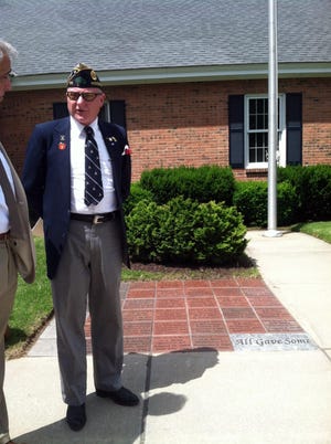 Todd Smith, commander of the Benson Fluegel American Legion Post 111 in Woodstock, stands in front of the Walk of Honor.