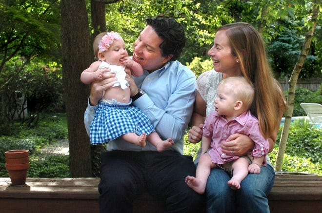 Doug and Emily Rodio in their new home in Medford, with their 8-month-old twins Andie (left) and Cameron.