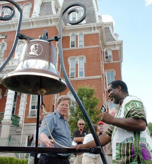 Rev. Gregory Perry of Greeneville Congregational Church rings the 250-pound bronze Freedom Bell at Norwich City Hall Saturday as City Historian Dale Plummer, left, looks on.