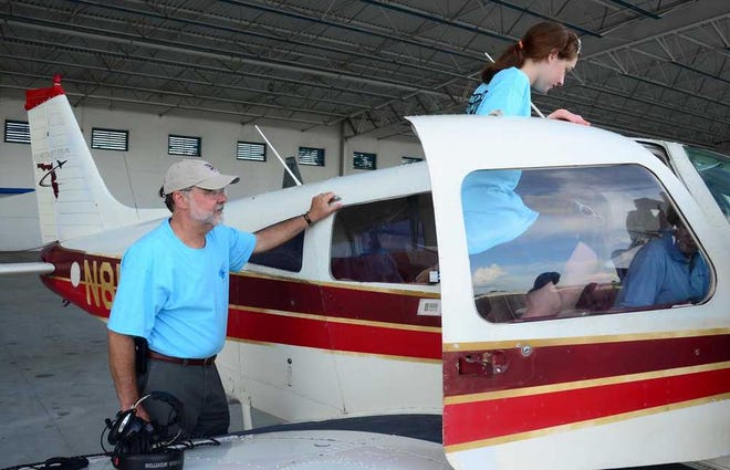 As Linwood Nooe watches, Florida School for the Deaf and the Blind student Katie Inman climbs into the plane before her flight. By PETER WILLOTT, peter.willott@staugustine.com