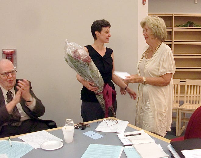 Silver Lake Regional School Committee Chairman Cassandra Hanson presents longtime superintendent's and School Committee secretary Margi Neil of Pembroke with flowers as she wraps up her career at Silver Lake during last Thursday night's committee meeting.