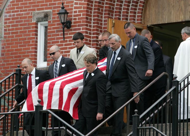 Photo by Tracy Klimek/New Jersey Herald - Pallbearers carry the casket of 68-year-old Stillwater resident Dennis Pegg down the stairs of St. Joseph Roman Catholic Church on Halsted Street in Newton on Friday.