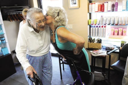 Margo Harrington, left, gets a kiss from her hairdresser of 35 years, Marga Coulp, before she gets her hair done Wednesday. Harrington is one of the last remaining members of the Red Cross Clubmobile in operation during World War II.