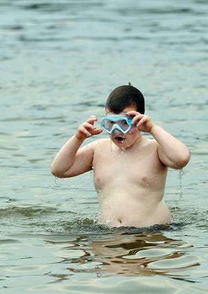 Tommy Fallon, 8, adjusted his goggles after surfacing from Beaver Pond in Franklin, Friday.