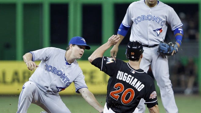 Miami Marlins' Justin Ruggiano (20) is tagged out at second base by Toronto Blue Jays second baseman Kelly Johnson, left, as Yunel Escobar backs up the play, after Ruggiano was caught off first in the second inning of an interleague baseball game in Miami, Friday, June 22, 2012. (AP Photo/Alan Diaz)