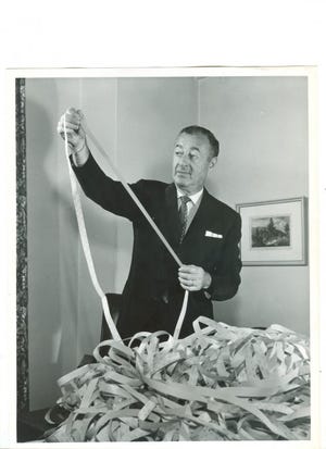 William J. Levitt looks over ticker tape of his company’s stock in this undated photo.