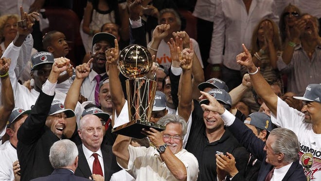 Miami Heat owner Micky Arison holds the the Larry O'Brien NBA Championship Trophy after Game 5 of the NBA finals basketball series against the Oklahoma City Thunder, Thursday, June 21, 2012, in Miami. The Heat won 121-106 to become the 2012 NBA Champions. (AP Photo/Wilfredo Lee)