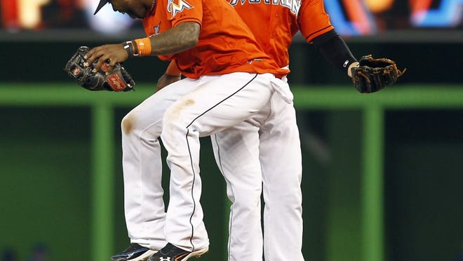 Miami Marlins players Jose Reyes, front, and Greg Dobbs celebrate after an interleague baseball game against the Toronto Blue Jays in Miami, Sunday, June 24, 2012. The Marlins won 9-0. (AP Photo/J Pat Carter)