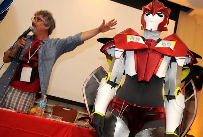 Clara Hall, of Waco, Texas, donned her Transformers "Knockout" costume to win a contest during the Savcon Transformers convention Saturday in Savannah. Neil Kaplan, at left, the voice of "Optimus Prime," helped judge the contest. (Photo by Carl Elmore/For the Savannah Morning News)