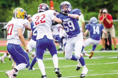 Winnacunnet’s C.J Wooster (59) of the East blocks West’s Colin Pellerin (Hollis-Brookline) on Saturday afternoon at the University of New Hampshire’s Cowell Stadium.