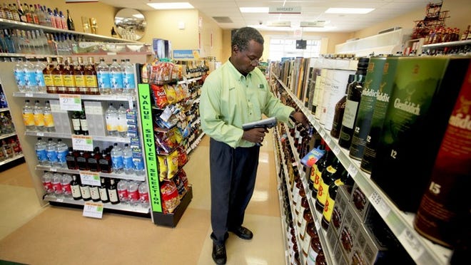Liquor store specialist Frederick Price scans bottles to check his inventory at the Publix liquor store on Hood Road in Palm Beach Gardens. Publix has opened 146 liquor stores since 2003.