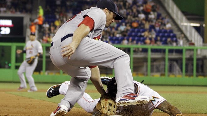 St. Louis Cardinals third baseman David Freese tags out Miami Marlins' Jose Reyes during the third inning of a baseball game, Monday, June 25, 2012, in Miami. (AP Photo/Terry Renna)