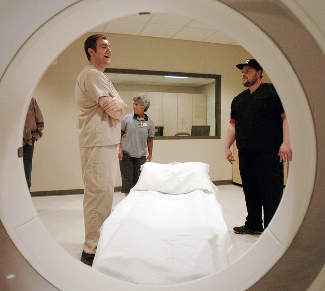Eric Moody, left, and Dolores Kubicki, both CT technicians, and Phil Kopplin, emergency department technician, check out a CT scanner Tuesday after ribbon cutting ceremonies at the Backus Emergency Care Center in Plainfield.