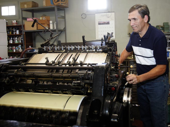 Mike Acosta works a printing press Thursday afternoon in Bazet Printing in Houma.