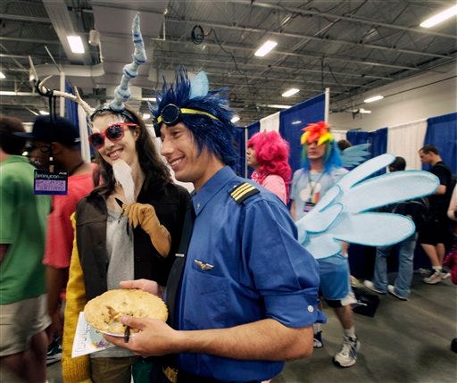 In this Saturday, June 30, 2012 photo, people dressed in My Little Pony cartoon costumes stand at "BronyCon" in Secaucus, N.J. Scores of men in brightly colored costumes were among the 4,000 My Little Pony fans at this weekend's "BronyCon" gathering in New Jersey for fans of the cartoon. "Bronies" are guys who like "My Little Pony: Friendship is Magic" and say they're misunderstood. They say there's nothing weird about their love for a show geared mainly to girls. They say they're fans because of great stories, characters and animation. (AP Photo/Mel Evans)
