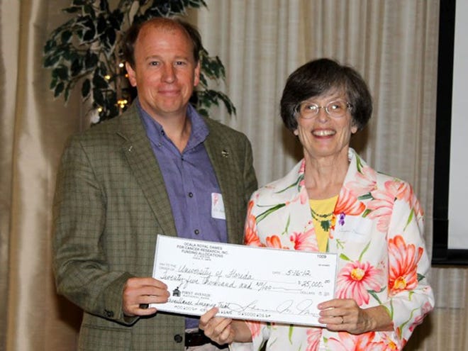Ocala Royal Dames member Gwynn Pealer, right, presents a grant to Dr. Walter O'Dell for his breast cancer study at UF Shands Cancer Center. (Photo courtesy of Ronald Wetherington)