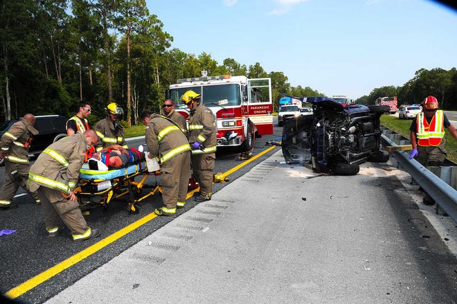 St. Johns County firefighters help a person who was injured in a car accident in Interstate 95 North near mile marker 320 on Saturday afternoon. By PHILLIP WHITLEY, Special to The Record