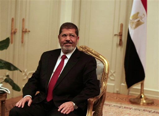Egyptian President Mohammed Morsi looks on during a photo opportunity during his meeting with Turkish Ambassador to Egypt, Hussein Awny and Turkish Foreign Minister Ahmet Davutoglu, unseen, at the Presidential Palace in Cairo, Egypt, Monday, July 2, 2012. Morsi, whose appointment is the fruit of Egypt's own uprising, said in a statement that he welcomes the opposition groups to Cairo and stressed the need for a political solution to end the crisis in Syria. (AP Photo/Maya Alleruzzo)