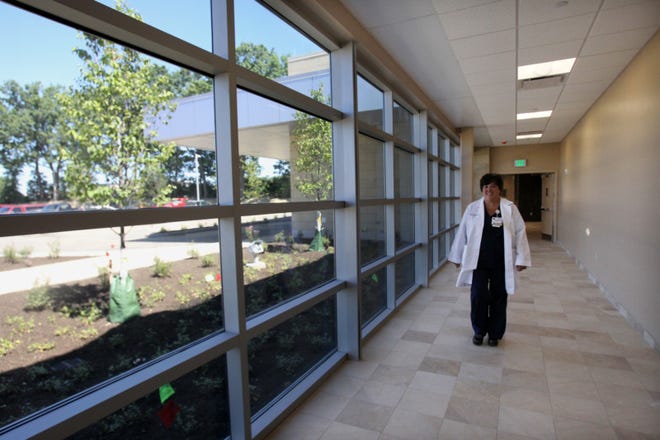 Christine Snow, the RN unit manager at the new Summa Emergency Department, walks down a windowed corridor at the new Summa Emergency Department in Green. The hallway will allow clients seeking outpatient services to avoid the emergency department. (Karen Schiely/Akron Beacon Journal)