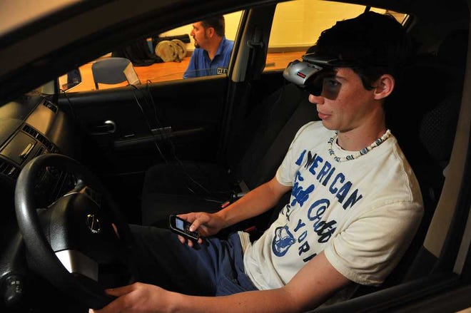 Photos by Bruce.Lipsky@jacksonville.com Logan Evans, 14, a student at Stanton College Preparatory School, sits in a computerized car with a virtual headset that shows potential traffic hazards as he texts while "driving." It's part of the AT&T program "Txting & Driving ... It Can Wait."