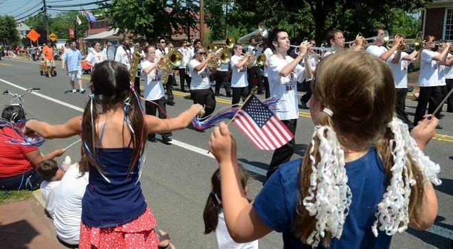 Polla Daghestani, 9 and Melanie Wolfson, 9, both from Evesham wave their flags and streamers as the Cherokee High School Marching Band passed by down Main Street during Evesham's Fifth Annual Fourth of July Celebration.