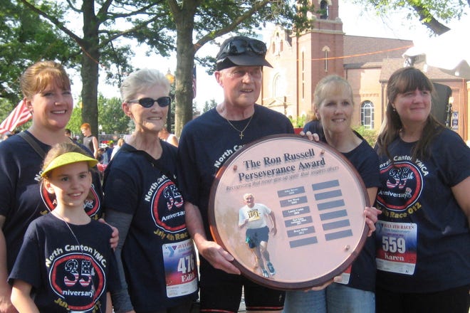 Bruce Miller (center) is surrounded by family after receiving the Ron Russell Perseverance Award at the North Canton Fourth of July Race.