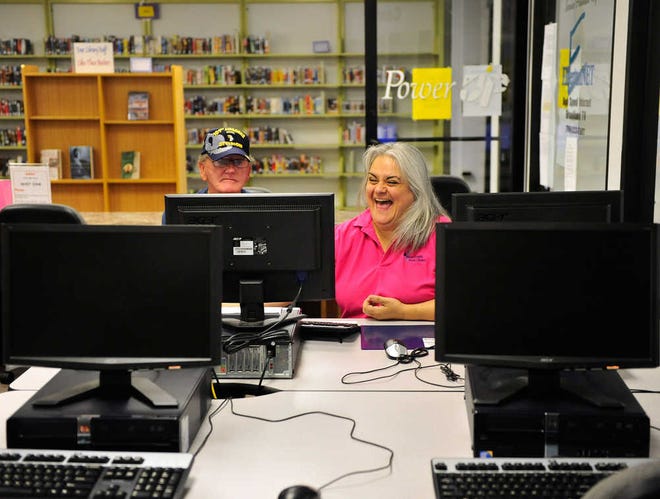 Janet Burroughs, right, shares a laugh with Jamie Black as she helps Black job search at the Elbert County Library Career and Small Business Center on Monday, July, 2, 2012 in Elberton, Ga. Richard Hamm/Staff (OnlineAthens/Athens Banner-Herald)