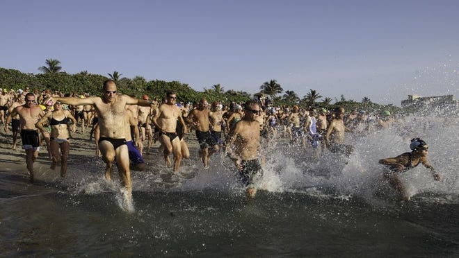 Long-distance swimmers dash toward the Atlantic Ocean at the start of Palm Beach County Rescue’s Ocean Mile Swim at Carlin Park in Jupiter Saturday morning. The event, which is in its fourth year followed a 1-mile, angled course and drew 209 swimmers.