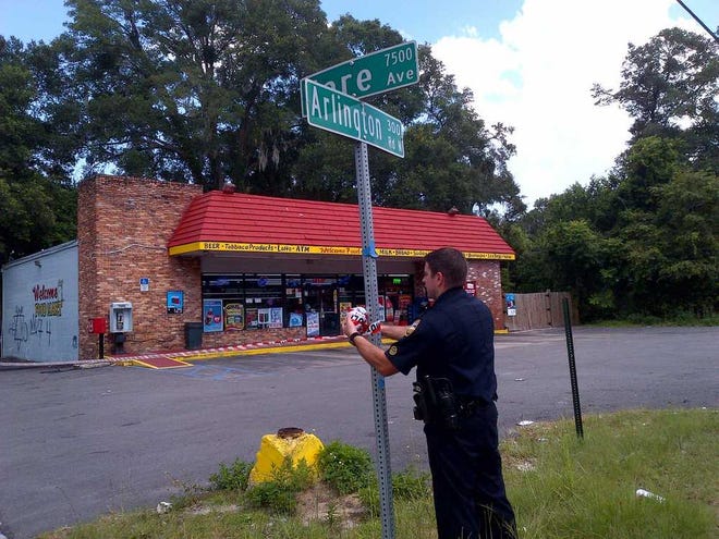 Jim.Schoettler@jacksonville.com A police officer takes down police tape outside a food store at the corner of Hare Avenue and Arlington Road, where a stabbing victim sought help.