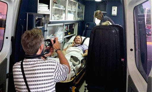 In this image provided by Tom Adkins, Andy Copeland takes a photo of his daughter, Aimee, as she leaves a hospital in Augusta Ga., Monday, July 2, 2012, headed for an inpatient rehabilitation clinic. Copeland left a Georgia hospital just weeks after a flesh-eating disease took her limbs but not her life. After nearly two months of battling the rare infection, called necrotizing fasciitis, Copeland headed to an inpatient rehabilitation clinic, where she'll learn to use a wheelchair after having her left leg, right foot and both hands amputated. (AP Photo/Tom Adkins)