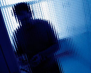 Person standing behind the opaque glass of a door
