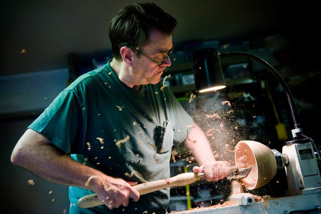 Richard Meador creates a bowl from a piece of wood last week at the home of Ernest Hilderbrand.