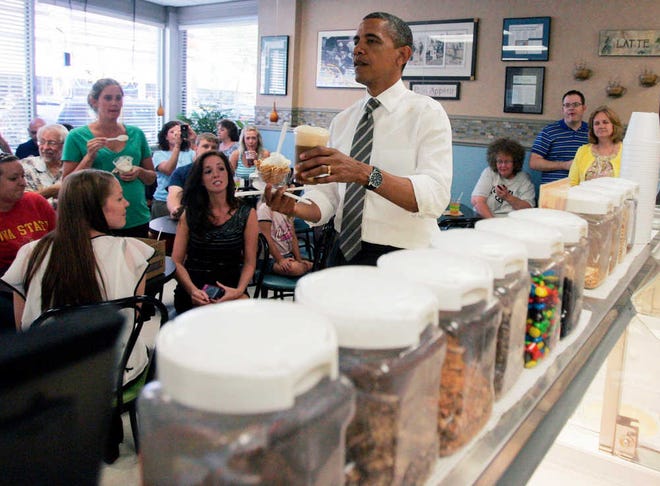 President Barack Obama brings ice cream to members of his staff during a stop at Deb's Ice Cream and Deli in downtown Cedar Rapids, Iowa, before heading to the airport on Tuesday.