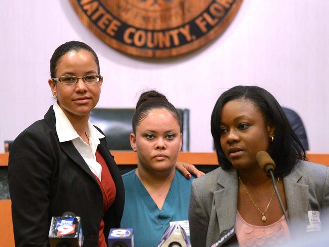 Lisa Wade, center, the mother of a boy whom a teacher described on Facebook as "the evolutionary link between orangutans and humans," attends a news conference with attorneys Alisia Adamson, left, and Sasha Watson on Tuesday in Bradenton. (Dan Wagner/Sarasota Herald-Tribune)