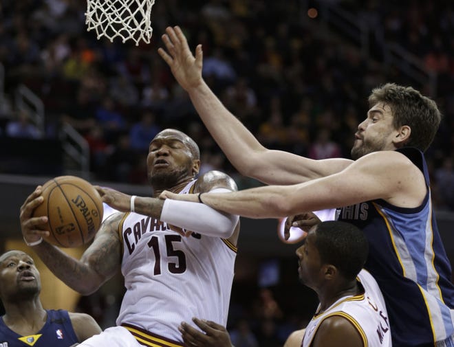 Cleveland Cavalier's Marreese Speights (left) grabs a rebound ahead of Memphis Grizzlies' Marc Gasol during a game March 8, in Cleveland. Speights has signed a three year deal with the Golden State Warriors. (AP Photo/Tony Dejak)